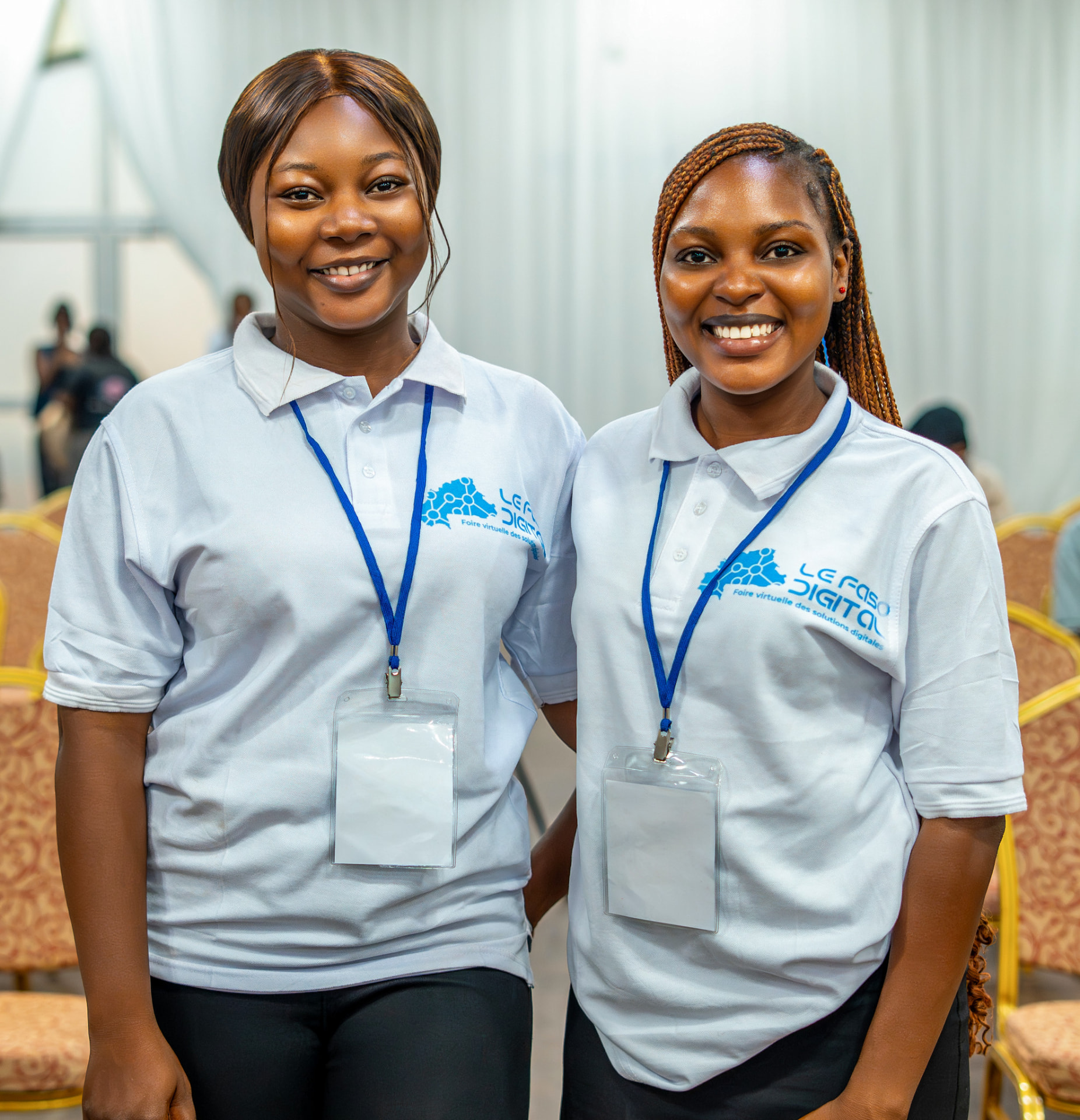 Deux hôtesses souriantes en polo blanc lors d’un salon