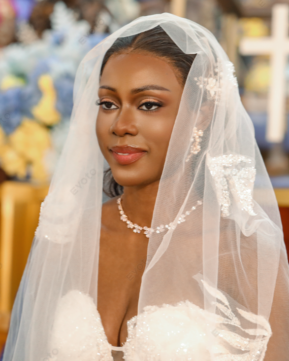 Mariée sous son voile orné de perles, regard tendre